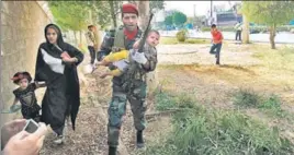  ??  ?? An Iranian soldier carries a child at the site of an attack in the southweste­rn city of Ahvaz.