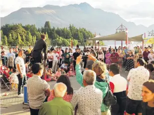  ?? PHOTO: GUY WILLIAMS ?? Centre of attention . . . A busker draws a crowd on Queenstown’s waterfront.