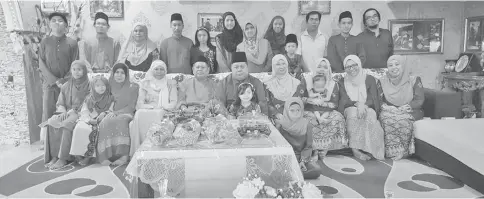  ??  ?? Ahmad (seated, sixth left) and his wife Fatimah Lee (seated, fourth right) pose with family members and guests at his open house.