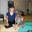  ??  ?? Pamela Gormish, owner of Blue Zen Wellness Collective in Pottstown, stretches out her leg while her dog Sailor, an American Pit Bull Terrier, licks her face at the wellness studio. “Doga” is combing the practice of yoga while spending time with dogs.