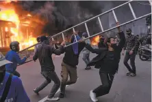  ?? Ed Wray / Getty Images ?? Protesters try to ram a ladder through the entrance of a subway station in the downtown area of Jakarta, Indonesia.