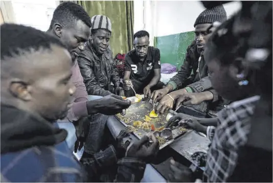  ?? Zowy Voeten ?? Migrantes africanos comparten plato en un piso del Besòs en el que viven hasta 15 personas.