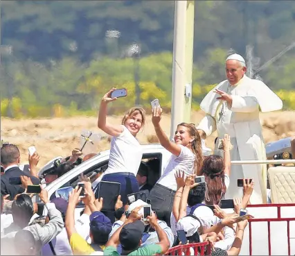  ??  ?? ASSOCIATED PRESS Pope Francis waves to the smartphone-carrying crowd Monday as he rides through the park where he celebrated Mass in Guayaquil, Ecuador. A crowd estimated at several hundred thousand people greeted Francis on the packed dirt of Samanes...