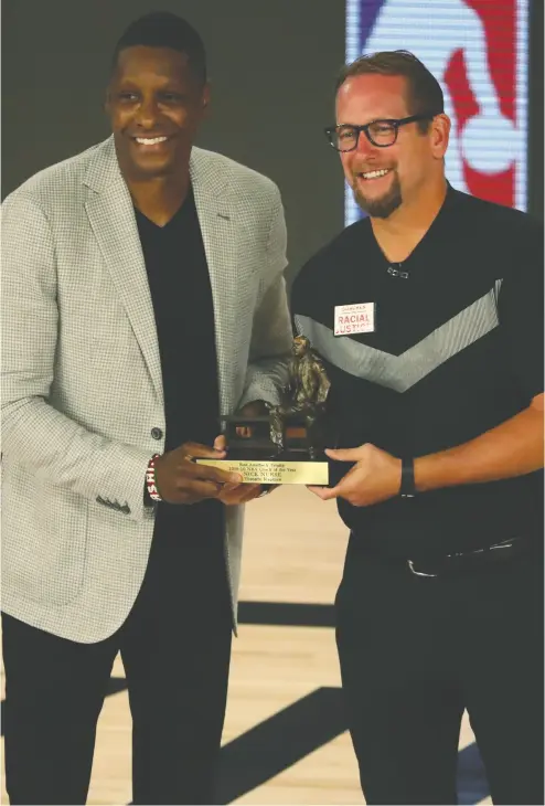  ?? KIM KLEMENT / POOL VIA THE ASSOCIATED PRESS FILES ?? Toronto Raptors team president Masai Ujiri, left, seen last year presenting head coach Nick Nurse his NBA
Coach of the Year award, is being tight-lipped about his profession­al future.