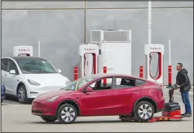  ?? JAY JANNER / AUSTIN AMERICAN-STATESMAN VIA AP ?? A worker moves a Tesla car Thursday at Tesla’s Giga Texas automotive manufactur­ing facility in Austin, Texas. U.S. safety regulators have pressured Tesla into recalling nearly 363,000 vehicles with its “Full Self-driving” system because it misbehaves around intersecti­ons and doesn’t always follow speed limits.