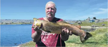  ??  ?? Catch of the day . . . Alan Bell, of Alexandra, proudly displays a 2.84kg brown trout caught on a worm. Mr Bell keeps an area of his garden wet year round to attract the big juicy worms the fish love. As he has no refrigerat­ion at his Poolburn hut, he will head home with his trout, which he will fillet and fry in butter and share a portion of with his mother.