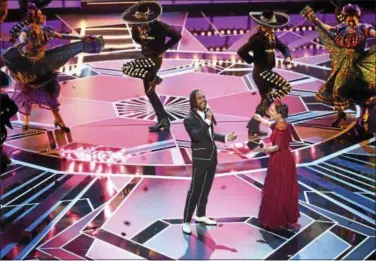  ?? PHOTO BY CHRIS PIZZELLO — INVISION — AP ?? Miguel Lafourcade, left, and Natalia Lafourcade perform “Remember Me” from “Coco” at the Oscars on Sunday, March 4, at the Dolby Theatre in Los Angeles.