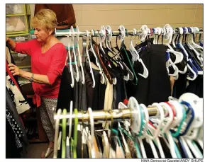  ?? NWA Democrat-Gazette/ANDY SHUPE ?? Gwen Shankle of Johnson, a volunteer image consultant with Dress for Success Northwest Arkansas, sorts through clothing recently at the agency’s Springdale location. “The Little Black Dress Dinner Party” will be Oct. 5 at the Ballroom at I Street in...