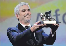  ?? FOTO: DPA ?? Da ist er, der Goldene Löwe: Der Mexikanisc­he Regisseur Alfonso Cuarón hat ihn erhalten für seinen Film „Roma“.