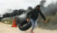  ?? (Mohamad Torokman/Reuters) ?? A PALESTINIA­N THROWS a tire during clashes last week with Israeli troops near Nablus.