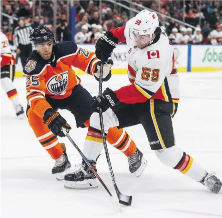  ?? JASON FRANSON/THE CANADIAN PRESS ?? Flames forward Dillon Dube battles Edmonton Oilers defenceman Darnell Nurse during NHL exhibition action. His play at training camp earned Dube a roster spot Monday.