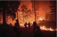 ?? NOAH BERGER / AP ?? Firefighte­rs monitor a backfire while battling the Delta Fire in the Shasta-Trinity National Forest, Calif., on Thursday.