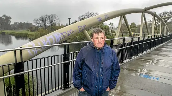  ?? JOHN KIRK-ANDERSON/STUFF ?? Christchur­ch local Tony Asquith has been waiting years for the new Medway St bridge to open and is disappoint­ed to see it vandalised within days.