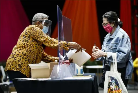  ?? Matt Rourke/Associated Press ?? A voter, right, checks in with an election worker before casting her ballot in the Pennsylvan­ia primary in Philadelph­ia on June 2.