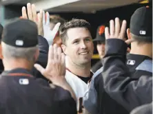  ?? Marcio Jose Sanchez / Associated Press ?? Catcher Buster Posey high-fives teammates after hitting a third-inning sacrifice fly to give the Giants a 2-0 lead.