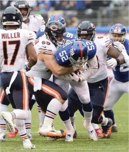  ?? AP ?? Alec Ogletree (52) is tackled by a host of Bears, including center Cody Whitehair (65), after intercepti­ng a pass from Chase Daniel.