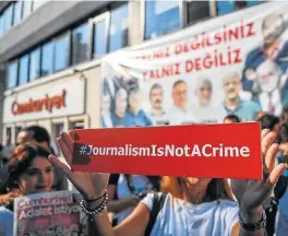  ?? /AFP ?? Free speech: A journalist holds a banner outside opposition newspaper Cumhuriyet in Istanbul, Turkey. Seventeen directors and journalist­s went on trial on Monday after eight months behind bars in a case that has raised alarm over press freedom under...