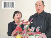  ?? HUO YAN / CHINA DAILY ?? Wang Minzheng and his wife show a decorative flour bun he made as an offering to the Yellow Emperor in Huangling, Shaanxi province.