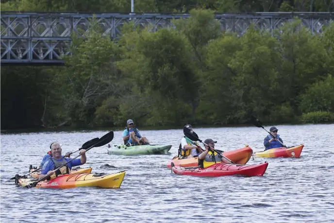  ?? NICOLAUS CZARNECKI PHOTOS / HERALD STAFF ?? TESTING THE WATERS: Bay State lawmakers and environmen­talists, including Republican Rep. James M. Kelcourse, right, kayak on the Merrimack River in Lowell on Friday. State Sen. Edward J. Kennedy (D-Lowell), top far right, joins the excursion Friday in Lowell. The group comes ashore in Lowell, bottom far right