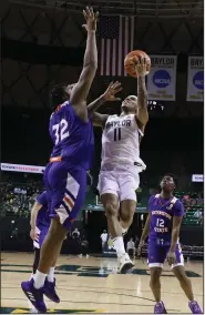  ?? (AP/Rod Aydelotte) ?? Baylor’s James Akinjo (11) goes up for a shot Tuesday against Northweste­rn (La.) State center Larry Owens during the topranked Bears’ 104-68 victory over the Demons in Waco, Texas. Akinjo scored a career-high 27 points as the Bears extended the nation’s longest winning streak to 18 games.