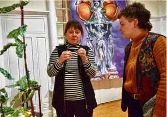  ?? ?? Danielle Lysaught (left), who turned the first floor of her Montreal home into an art gallery, discusses the exhibition “Identités” with a visitor.