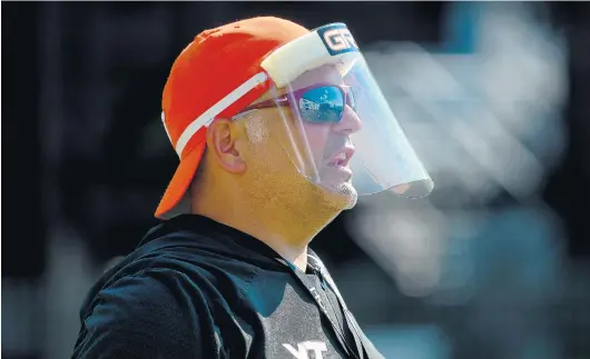  ?? COURTESY OF VIRGINIA TECH ATHLETICS ?? Justin Fuente, wearing a shield at a recent practice to guard against coronaviru­s, says, “I’ll feel really good about a large portion of our football team and what they can do.”