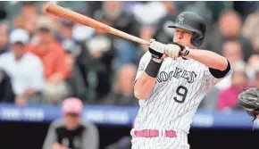  ??  ?? Colorado’s DJ LeMahieu can’t hold up while trying to check his swing on a pitch from Brewers starter Freddy Peralta. Peralta struck out 13 Rockies in his major-league debut on Sunday.