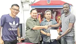  ??  ?? KASONDE IS BACK...Zambian player Francis Kasonde who played for Sabah Rhinos last season submitting his contract to Sabah FA vice president Benedict Asmat (2nd right) while shaking hands with Juil as Rhinos head coach Jelius (left) looks on.