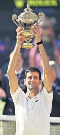  ??  ?? FELIZ. Novak Djokovic levanta la copa de campeón de Wimbledon.