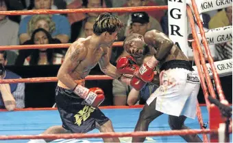  ?? / JEFF GROSS / ALLSPORT ?? Lehlohonol­o Ledwaba tries to dodge punches from Manny Pacquiao during their IBF junior featherwei­ght bout in 2001.