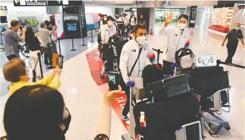  ?? KAZUHIRO NOGI / AFP VIA GETTY IMAGES ?? South Korean volleyball star Kim Yeon-koung and teammates arrive at Narita Internatio­nal Airport in Japan’s Chiba prefecture on Monday. An iron curtain at the border, it was not, Scott Stinson writes.