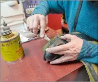  ?? ?? Jairo Cardenas, the owner of the Alpha Shoe Repair Corp., repairs a boot last month in New York. Business at the shop, which Cardenas has run for 33 years, is down 75% compared with prior to the pandemic. Shoe repairs typically bring in more money than shines.