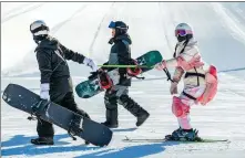  ?? DING GENHOU / FOR CHINA DAILY ?? Middle: Skiers in skiwear carry their gear at a ski resort in Hohhot, Inner Mongolia autonomous region, on Dec 19.