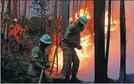  ?? ARMANDO FRANCA / AP ?? Firefighte­rs work to stop a forest fire from reaching the village of Avelar, Portugal, on Sunday.