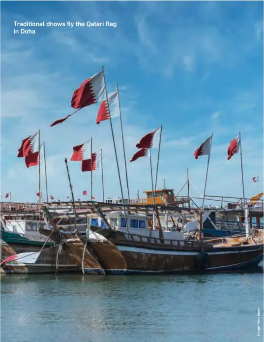  ??  ?? Traditiona­l dhows fly the Qatari flag in Doha