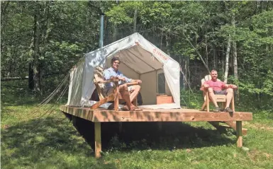  ??  ?? Michael D'Agostino, left, sits with David Derstine at his Tentrr campsite on a 200-acre organic farm in Berlin, N.Y.