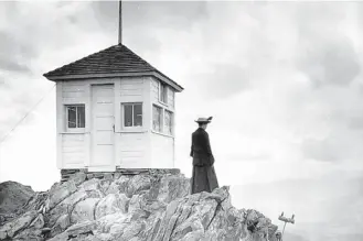  ?? FOREST HISTORY SOCIETY / CC FLICKR ?? A female fire lookout surveys the area around the Twin Sisters Fire Lookout Observator­y in Colorado’s Larimer County in 1917.