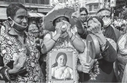  ?? Ashim Paul / Associated Press ?? Supporters holding a photograph of All India Trinamool Congress party chief Mamata Banerjee celebrate an early lead for the party in the West Bengal elections Sunday in Kolkata, India. Prime Minister Narendra Modi’s party trailed significan­tly there.