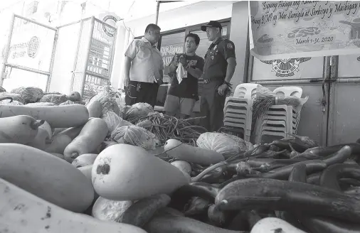  ?? BING GONZALES ?? PHILIPPINE Drug Enforcemen­t Agency XI assistant regional director Behn Joseph Tesiorna (left) interrogat­es Philip Jay Salip, a vegetable supplier of the Davao City Jail, who was arrested after illegal drugs were found in the delivered vegetables inside the facility on Thursday morning. At right is jail warden, Maj. Ian Glenn Ocmen.