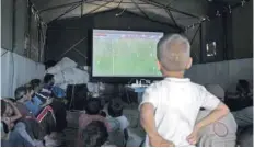  ?? — AFP ?? Displaced Syrians watch World Cup football match in Ain Issa camp in Raqa province on Sunday.