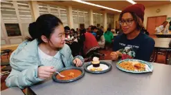  ?? — AP photos ?? Foreign exchange student Miaofan Chen, left, of Hefei, China, chats with Thandi Glick during a potluck meal for Chinese exchange students and their families at a school in Denver.