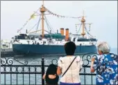  ?? XU SUHUI / XINHUA ?? Tourists examine a model of the a member of the Beiyang Fleets, in Weihai, Shandong province.