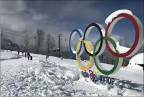  ?? JAMES ELLINGWORT­H — THE ASSOCIATED PRESS ?? Tourists walk next to the Olympic rings on the mountain resort of Krasnaya Polyana near the Black Sea resort of Sochi, southern Russia on March 3.