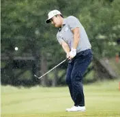  ?? RAY CARLIN AP ?? K.H. Lee chips onto the ninth green as rain falls during the final round of the AT&T Byron Nelson tournament.