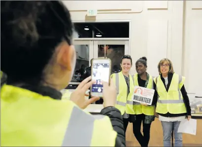  ??  ?? Nikolas Samuels/The Signal (See additional photos on signalscv.com) From left to right, Krysta Warfield, Nicole Feast-Williams and Linda Davies pose for a picture in their vests that were handed out at the Santa Clarita Activities Center as they...