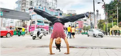  ?? —AFP photos ?? In this photo breakdance­r Johanna Rodrigues performs a dance move on a street in Bangalore.