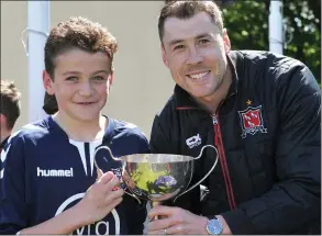  ??  ?? Ardee Celtic’s Tadhg McDonnell receives the Under-12 Cup from Dundalk’s Brian Gartland.