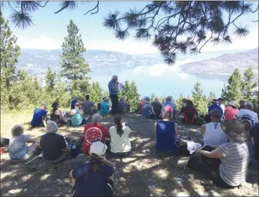  ?? HENRY SIELMANN/Submitted photo ?? David Gregory, in the plaid shirt, described the history of the Fur Brigade Trail at the recent Tea at the Summit celebratio­n as participan­ts sat under the tree eating cookies and drinking tea.