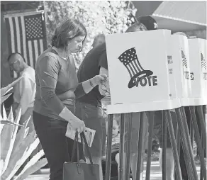  ?? MARK RALSTON/AFP/GETTY IMAGES IMAGES ?? People vote at outdoor booths during early voting for the midterm elections in Pasadena, Calif., on Saturday.