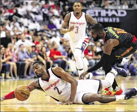  ?? ROB CARR / GETTY IMAGES ?? While clutch play by John Wall (left) has given the Wizards an edge in two victories, the Hawks’ Tim Hardaway Jr. (right) has struggled. He’s 7 for 25 from the field in the series and 2 for 10 from 3-point range.